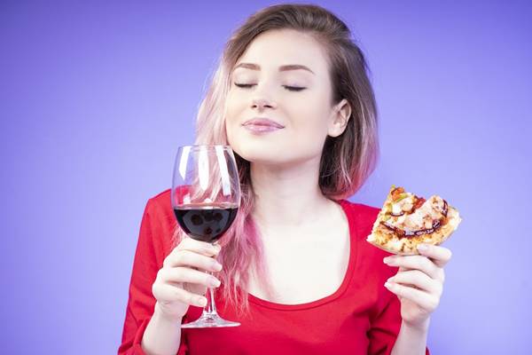 good-looking girl with a slice of pizza and a glass of red wine